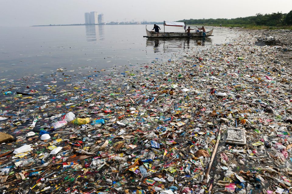 Fishermen prepare to fish, amidst floating garbage off the shore of Manila Bay